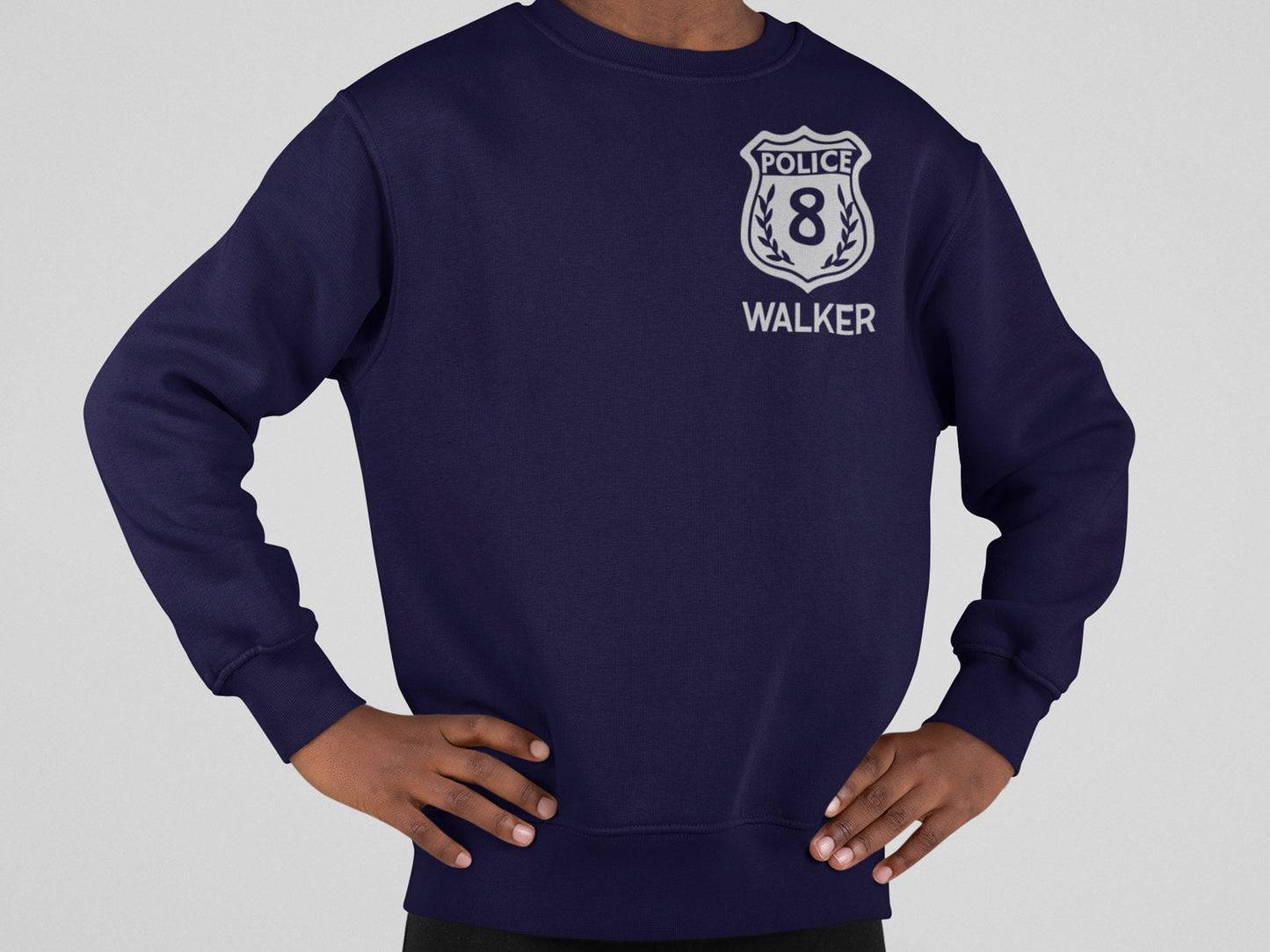 A navy blue sweatshirt with a silver police badge design. The badge has the word 'POLICE' and the number '8' inside. The text 'WALKER' is below the badge.