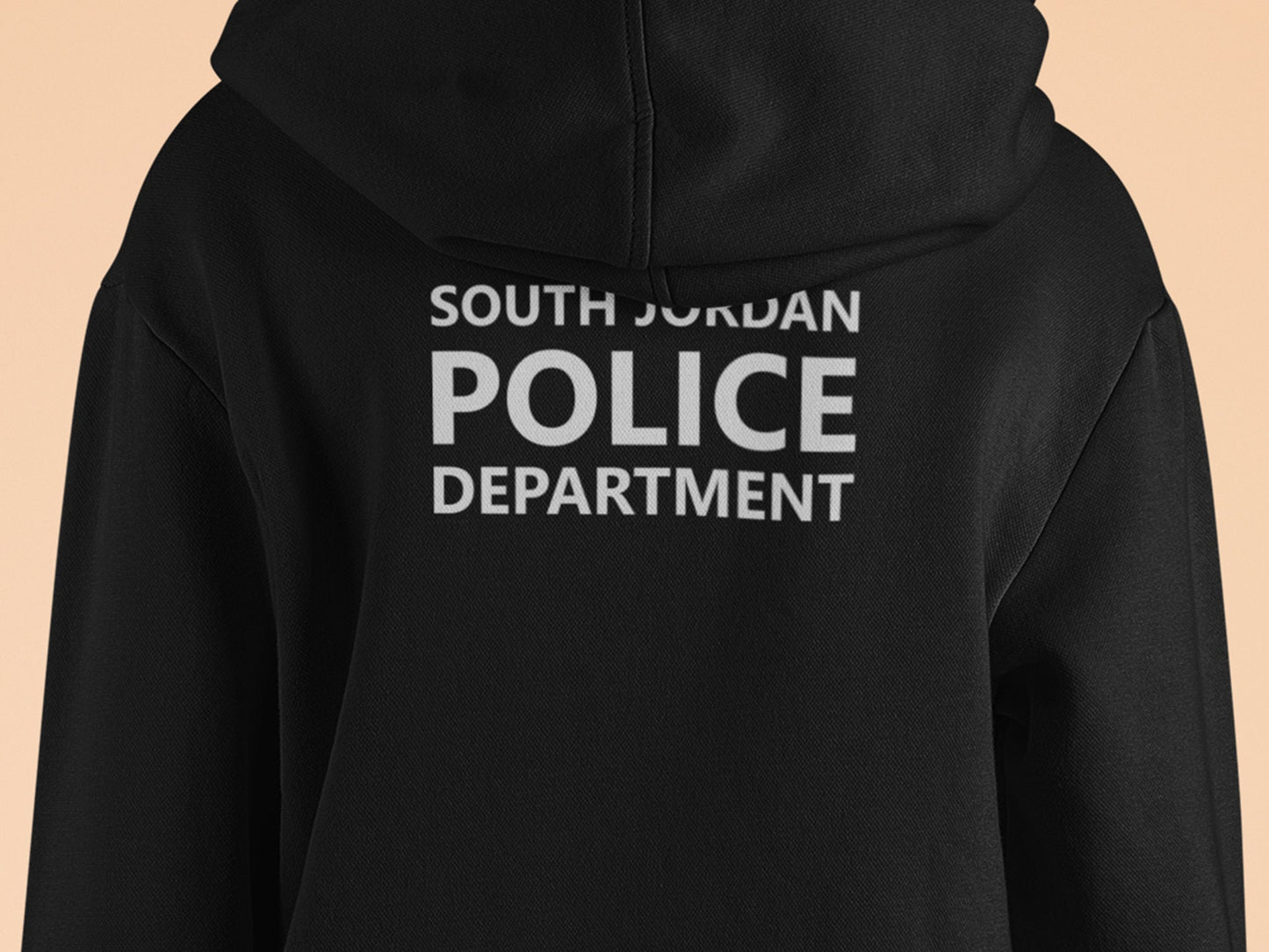 Black hooded sweatshirt with South Jordan Police Department text in white print on the back. The text is stacked vertically with 'SOUTH JORDAN' at the top, 'POLICE' in a larger font in the middle, and 'DEPARTMENT' at the bottom. The hoodie is a dark, solid color with a drawstring hood.