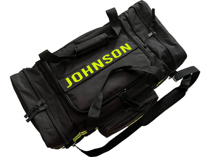 To view of black firefighter duffel bag with yellow text “Johnson” indicating the place for personalization.