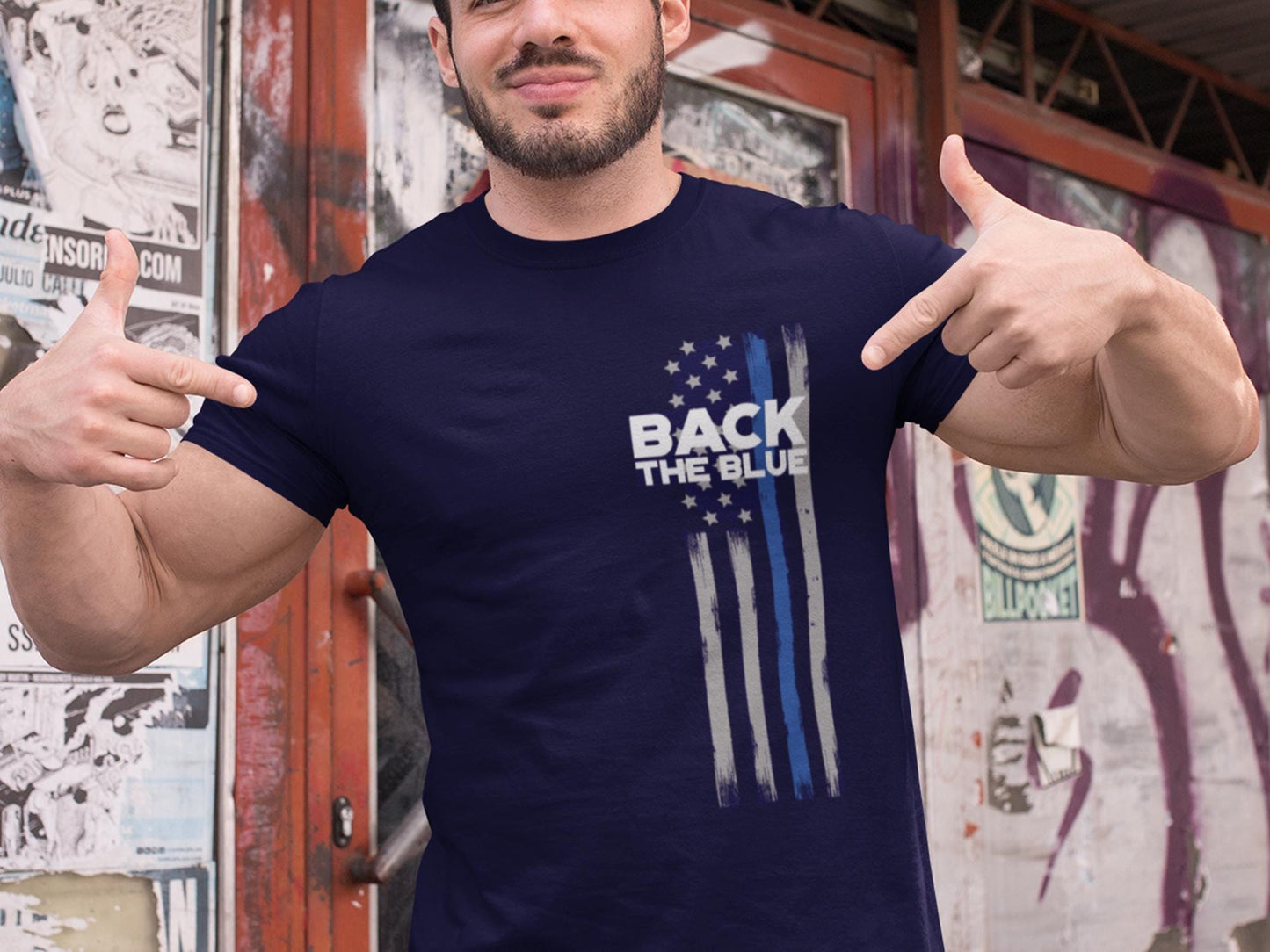 A navy blue t-shirt with a white and blue American flag design. The flag has a thin blue line running down the center. The text &#39;Back the Blue&#39; is printed in white on the t-shirt.