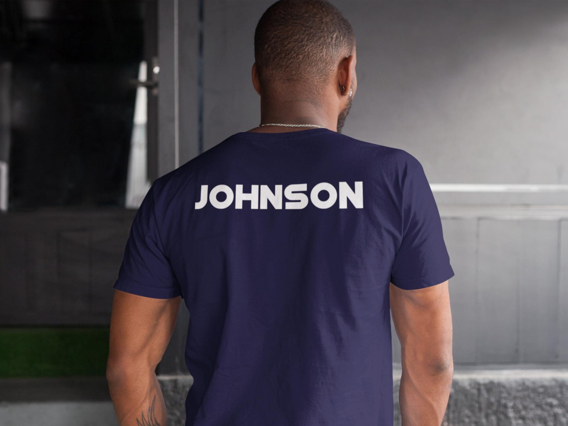 A navy blue t-shirt with the word &#39;JOHNSON&#39; printed in white on the back.