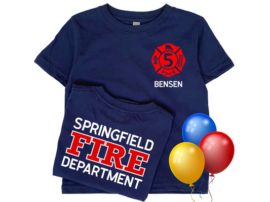 Navy blue kid’s birthday firefighter t-shirt with red Maltese cross that includes the number 5 indicating custom text for child’s age. Name is written below the badge and custom fire department printed on back in red and white text.