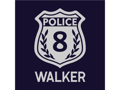 Closeup detail of a silver police badge with the number 8 in the middle and the name &#39;WALKER&#39; underneath on a navy blue background.