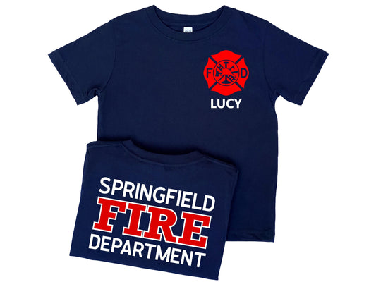Navy blue t-shirt in children sizes with custom red Maltese Cross on the front. The child&#39;s name is under the Maltese Cross. The folded back of the shirt is shown with a custom fire department name with &quot;Fire&quot; and &quot;Department&quot; underneath.