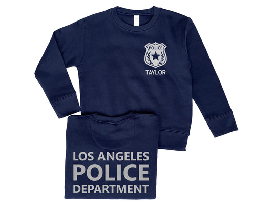 Navy blue crew neck sweatshirt with silver police badge on left chest and the name &#39;Taylor&#39; underneath. Back of sweatshirt says &#39;Los Angeles Police Department&#39; in silver text.